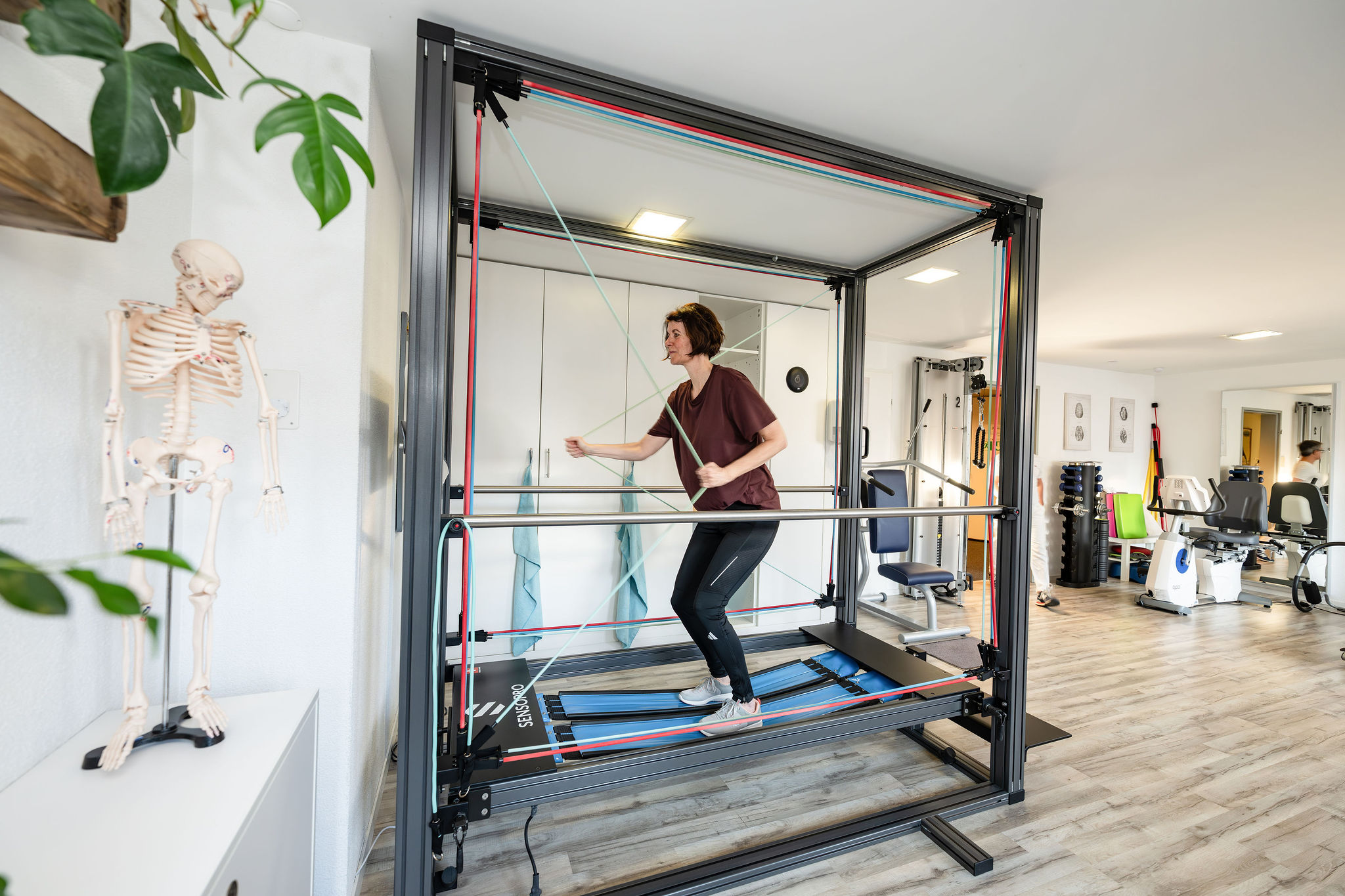 Patientin trainiert mit dem SENSOPRO Rehabilitationsgerät in der Physio Kinetic Praxis