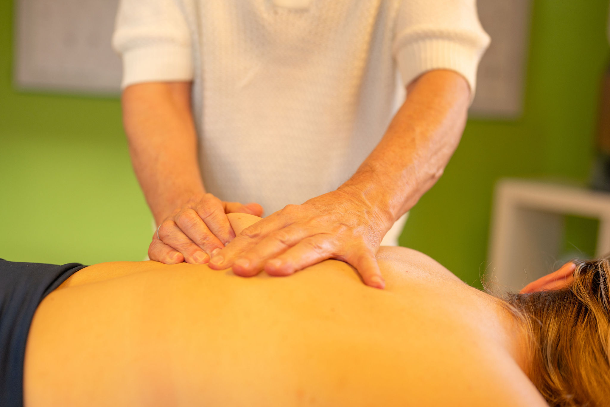 Physiotherapeut Manolito van Haren führt manuelle Therapie an der Rückenmuskulatur eines Patienten durch