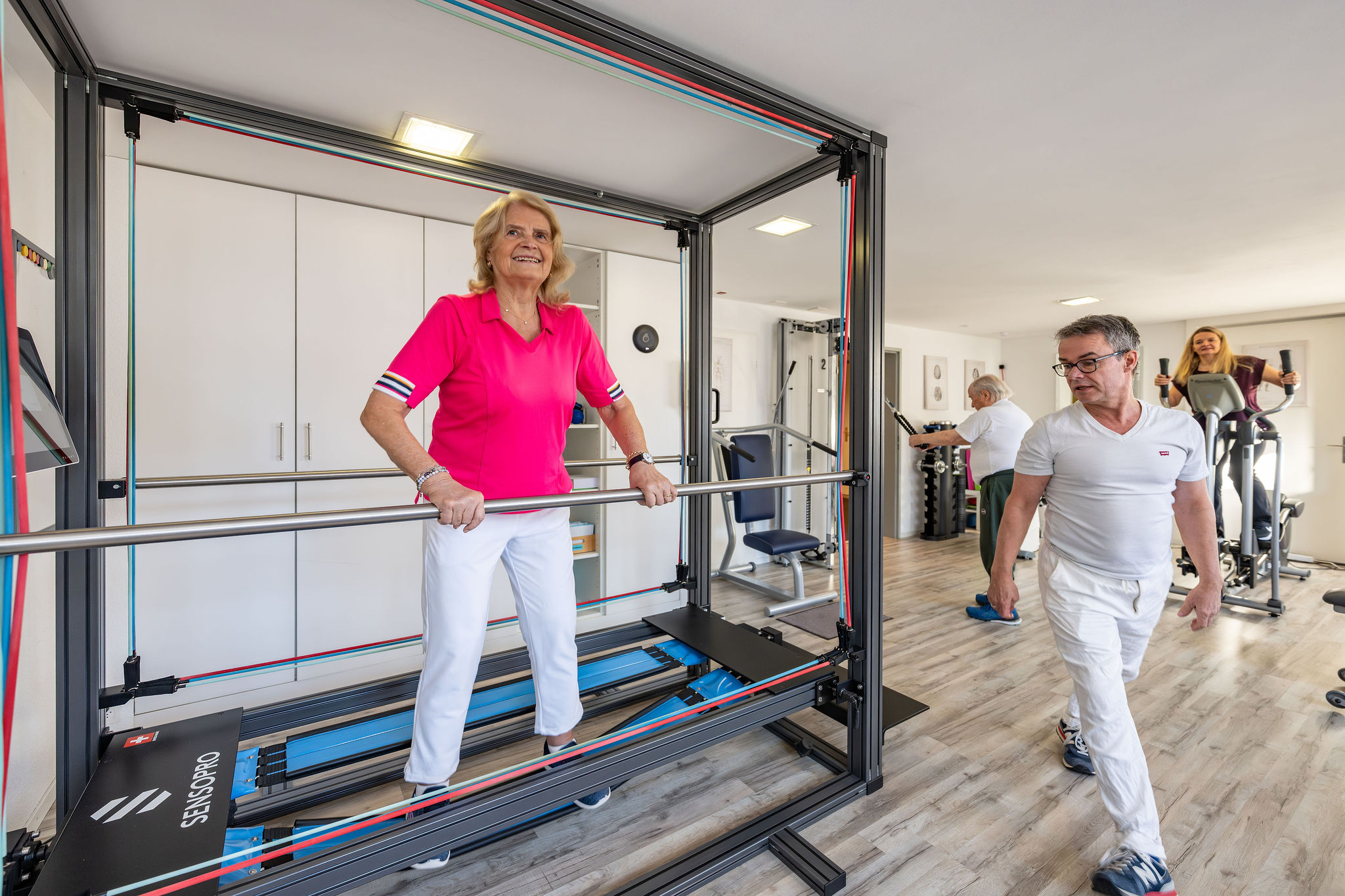 Patientin trainiert auf dem SENSOPRO Gerät unter Aufsicht von Physiotherapeut Manolito van Haren in Physio Kinetic